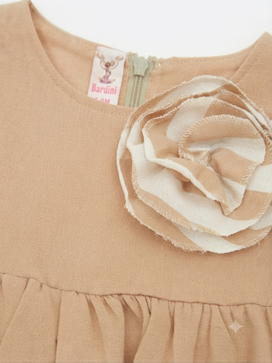 Vestido niña beige con olanes en capas y flor decorativa