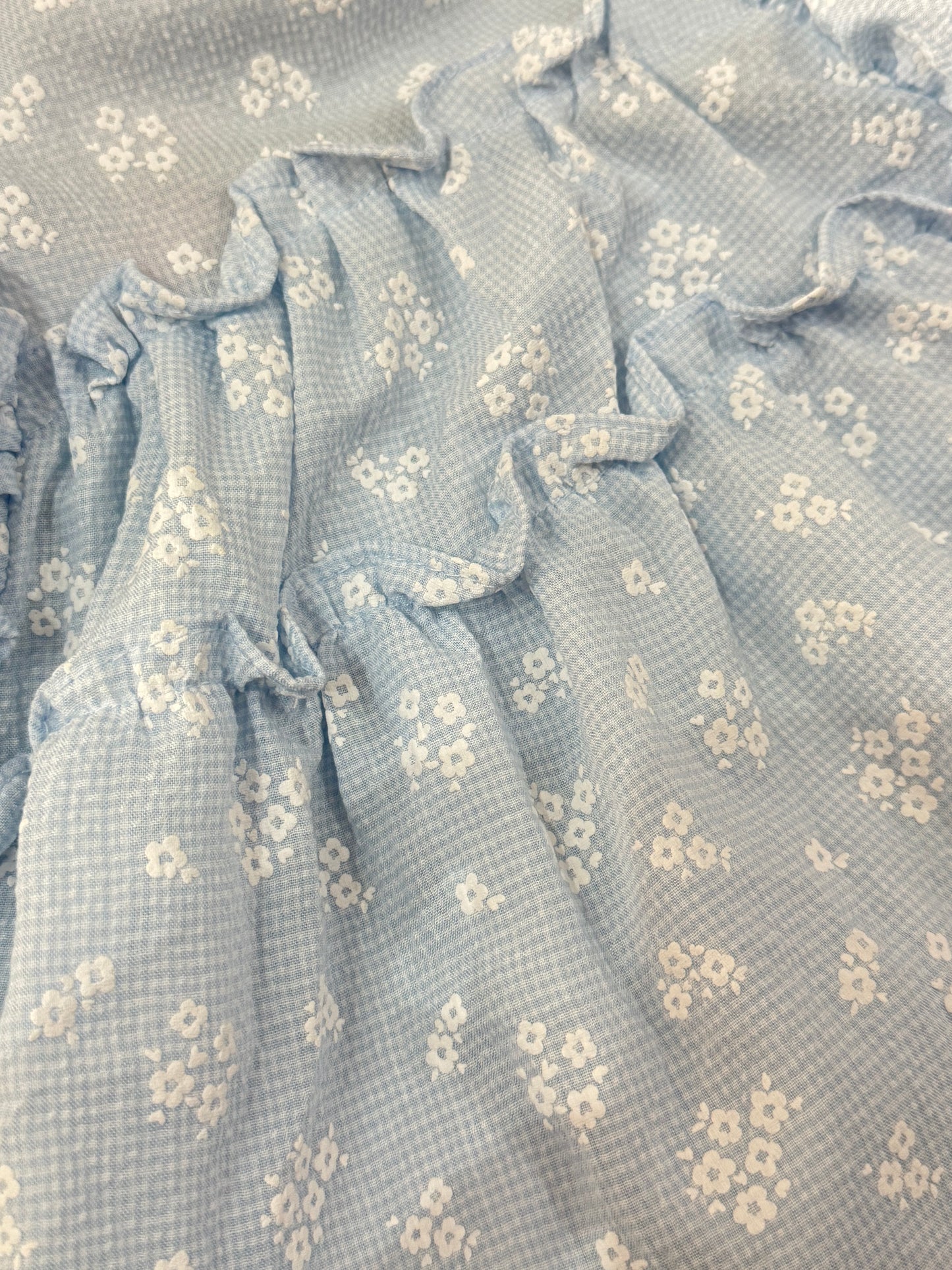 Set niña con blusa azul de olanes y leggings con flores