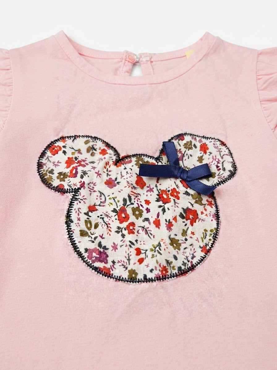Blusa niña rosa con aplique floral y olanes