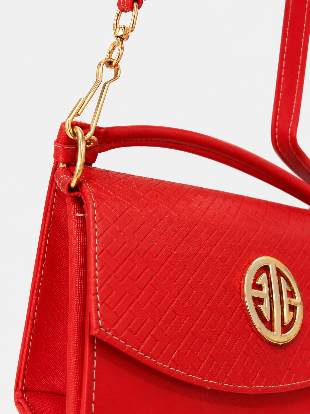 Bolsa dama roja elegante con textura grabada y herrajes dorados