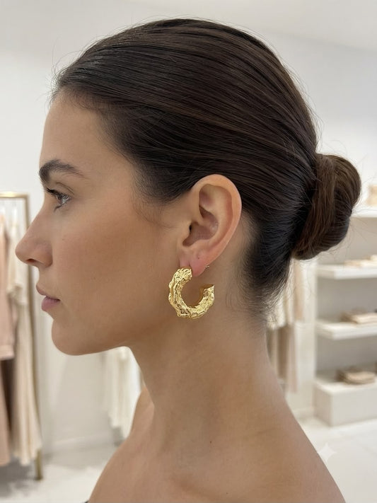 Aretes tipo huggie con textura martillada dorada